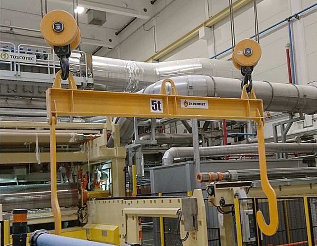 Trawersa suwnicowa z łapami do transportu tamborów w hali przemysłowej