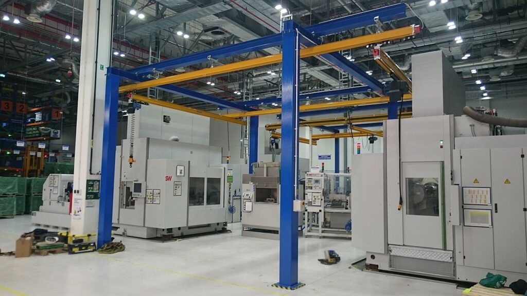 Niebieska konstrukcja wsporcza z żółtą suwnicą podwieszaną