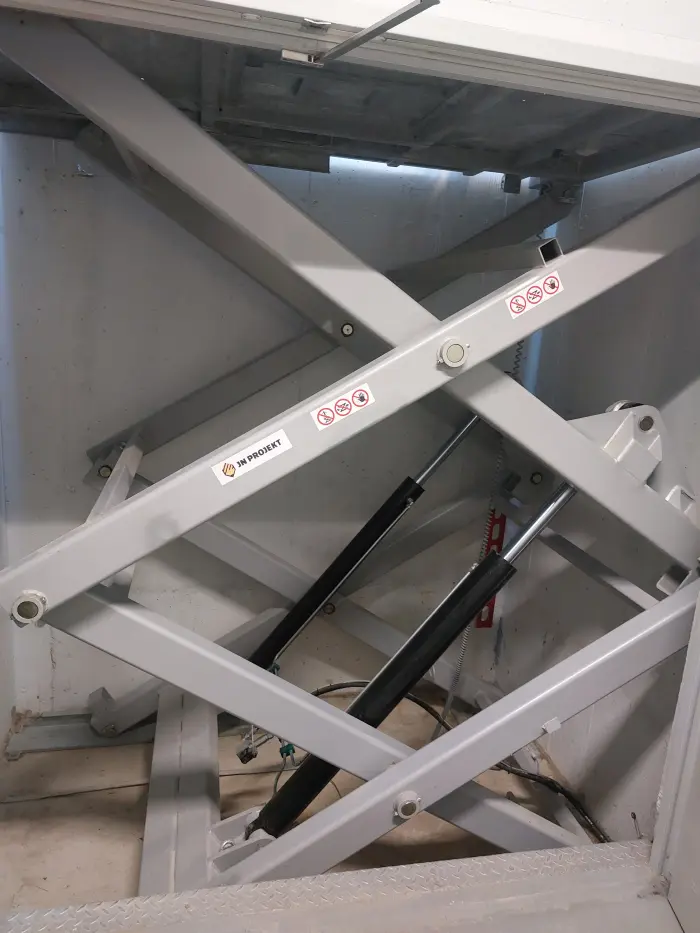 nożyce-podnośnika-z-dwoma-siłownikami-hydraulicznymi-do-dużych-obciążeń-kotwione-w-kanale-betonowym-parkingu-podziemnego.