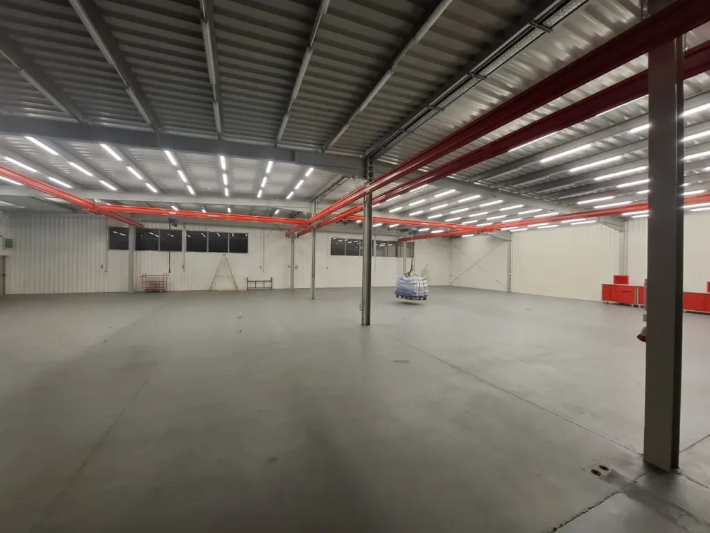 Podwieszony system suwnic modułowych z wciągnikami łańcuchowymi nad stanowiskami montażowymi