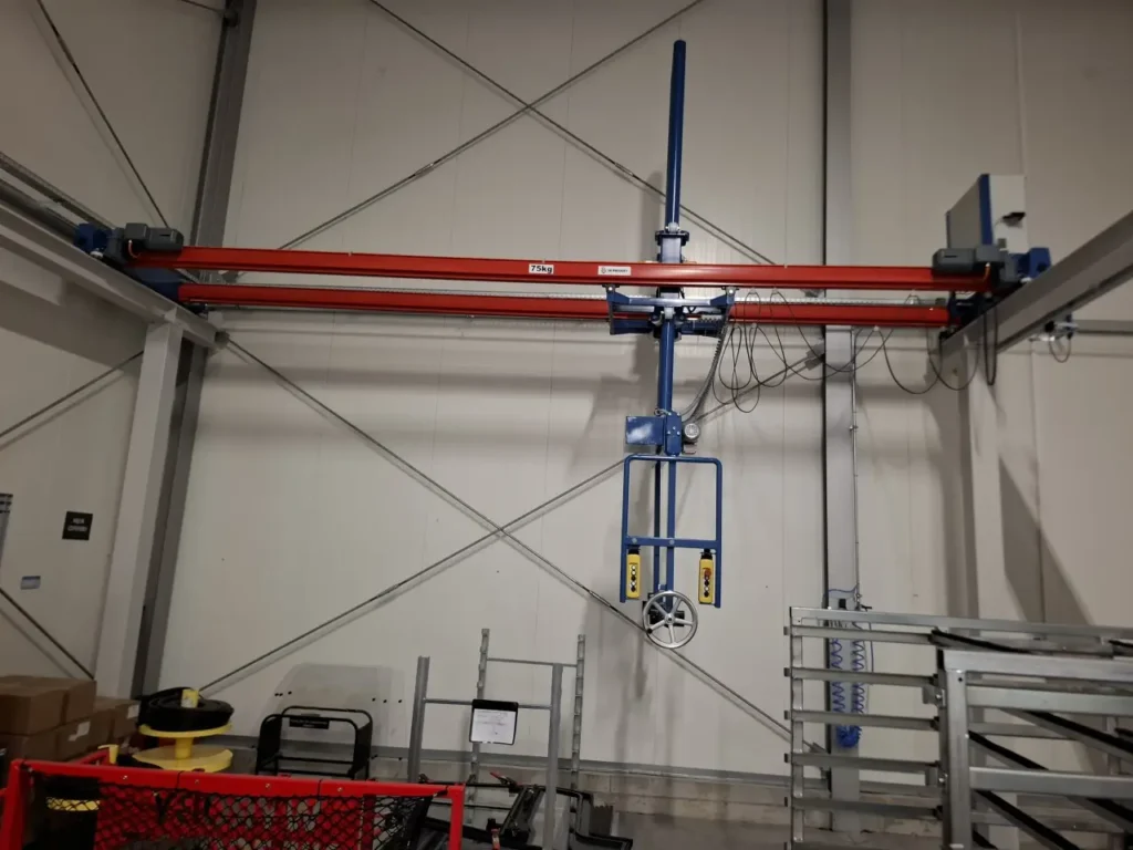 Suwnica technologiczna z manipulatorem i panelami sterowniczymi na estakadzie