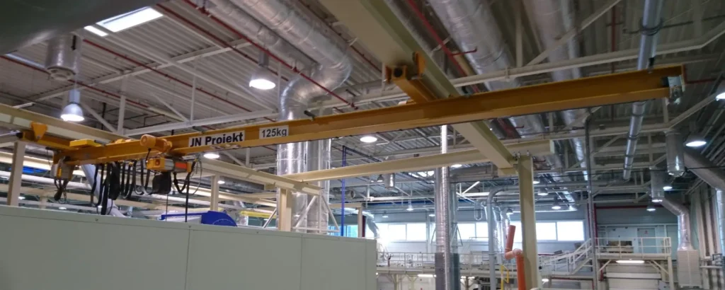 Podwieszana suwnica z wydłużonym wysięgiem do podnoszenia ładunków z antresoli i posadzki