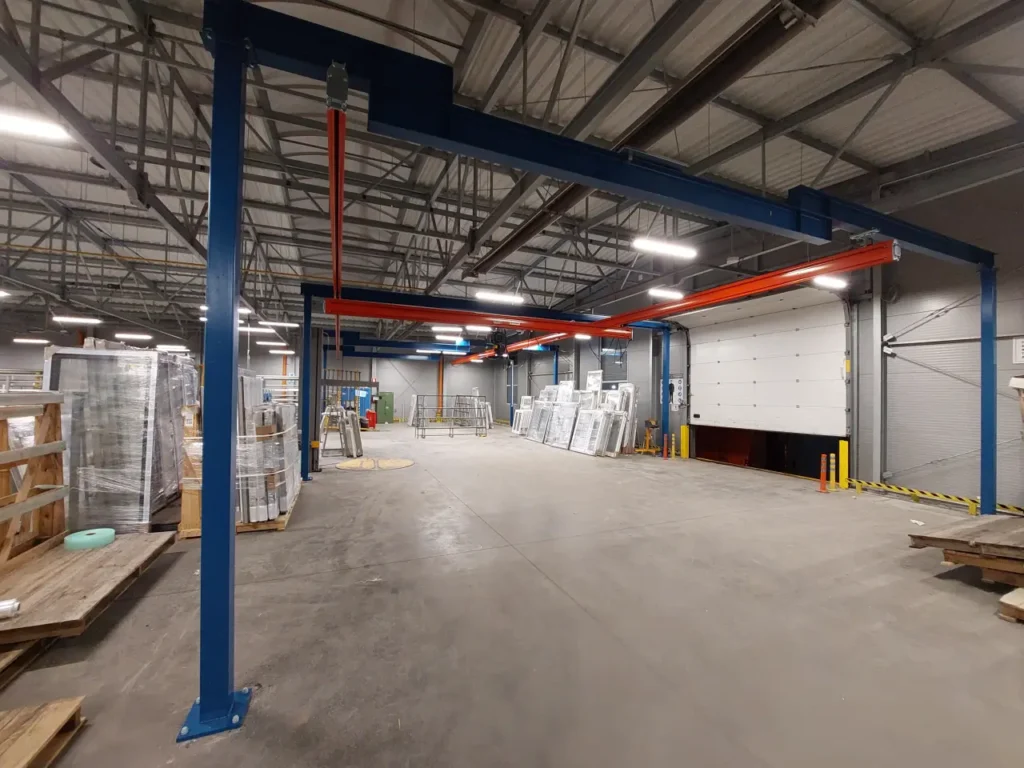 Suwnice modułowe z wciągnikami łańcuchowymi do obsługi pakowania okien w hali produkcyjnej